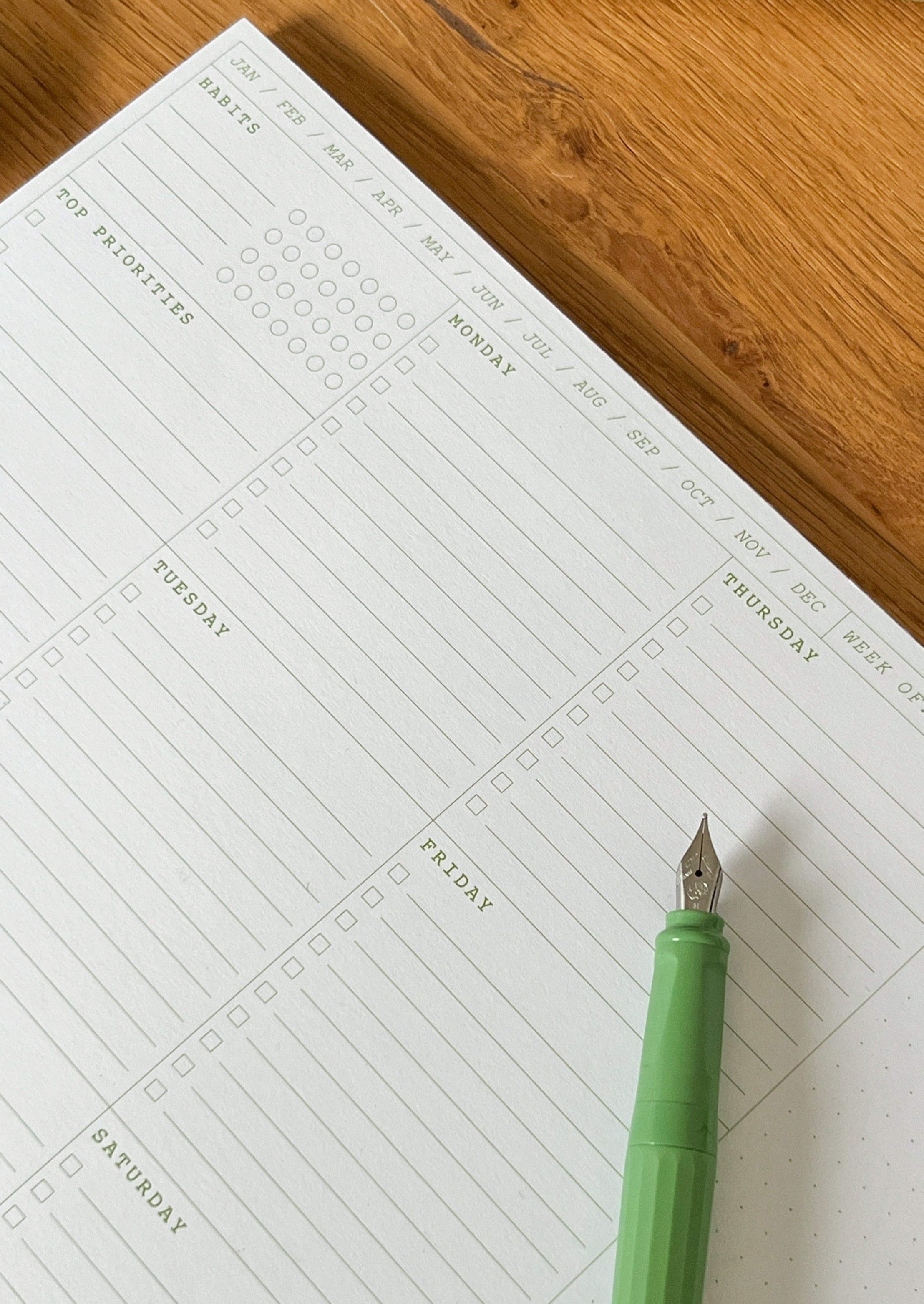 nóta póca A4 weekly desk pad in white and green on desk