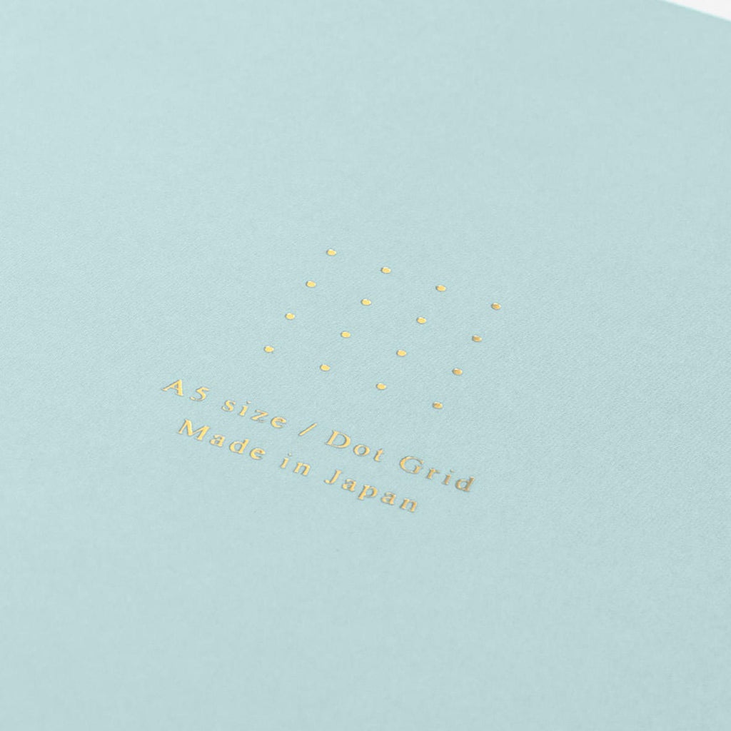 Midori A5 blue dot grid notebook with pen on desk
