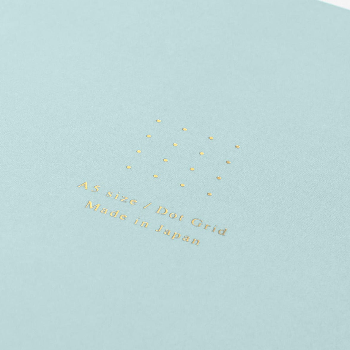 Midori A5 blue dot grid notebook with pen on desk