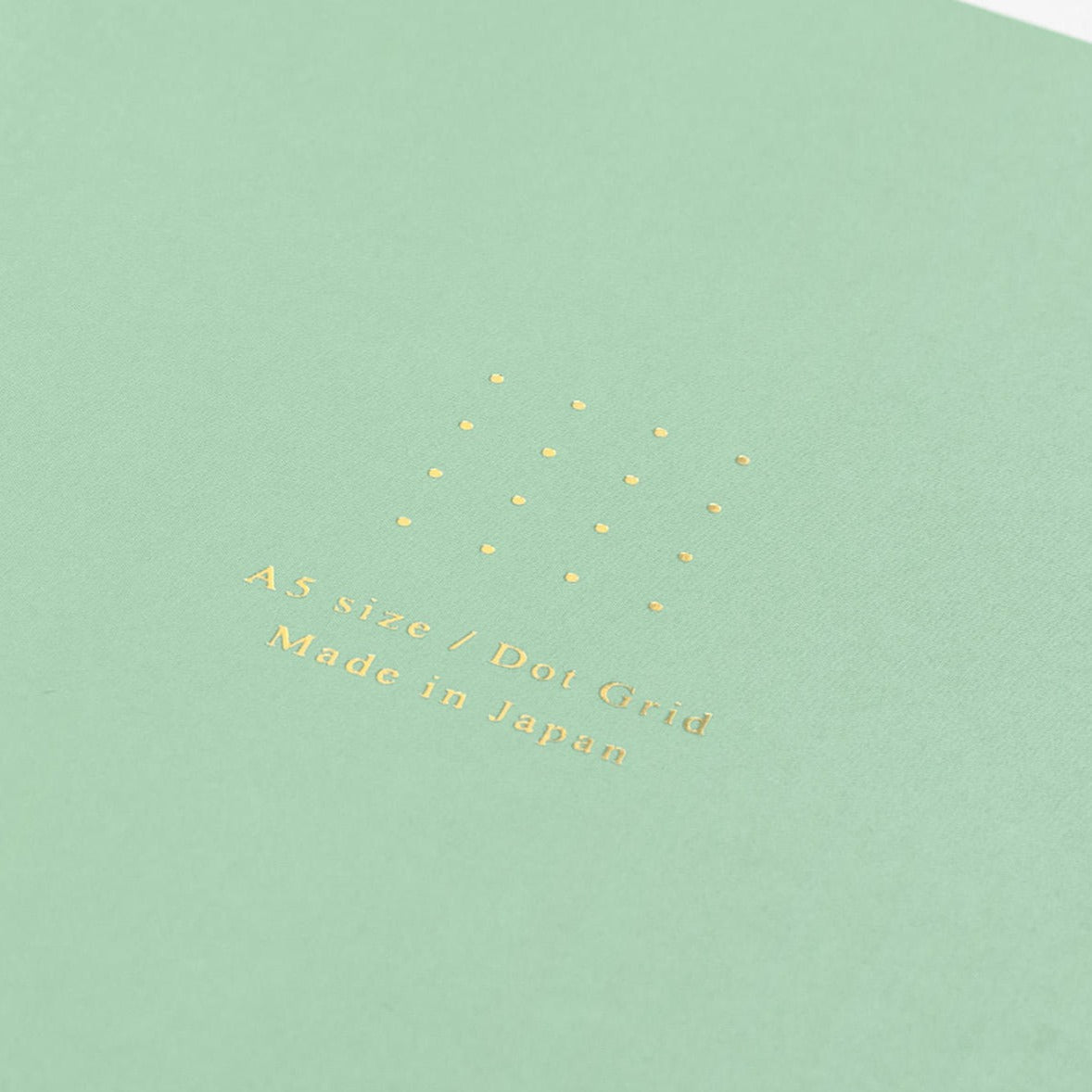 Midori A5 green dot grid notebook with pen on desk