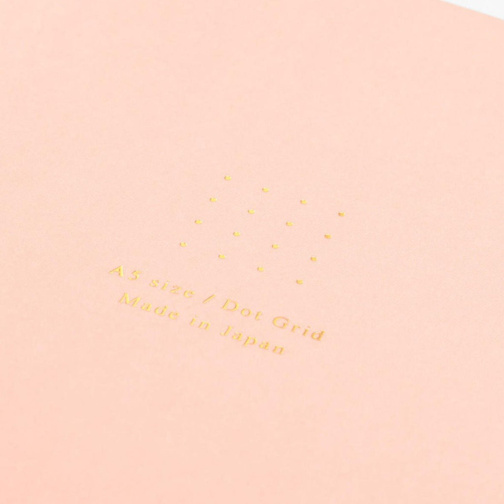 Midori A5 pink dot grid notebook with pen on desk