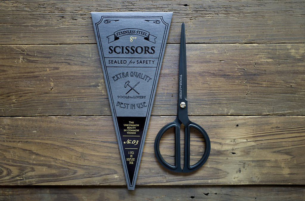 Tools to Liveby black scissors with notebook flat lay